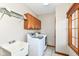 Functional laundry room with a utility sink, washer, dryer, and storage cabinets at 2446 Quiet Way, Indianapolis, IN 46239