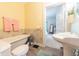 Yellow bathroom featuring a clawfoot tub, toilet, sink, floral wallpaper, and access to the bedroom at 282 N Mapleton St, Columbus, IN 47201