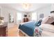 Bedroom featuring a bed with patterned bedding, bright windows, wood floors, and a modern-style mirror at 282 N Mapleton St, Columbus, IN 47201