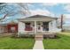Charming single-story home featuring a covered front porch with a swing, walkway, and well-maintained lawn at 282 N Mapleton St, Columbus, IN 47201