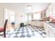 Spacious kitchen featuring white cabinets, blue counters, checkered floors, and access to another room at 282 N Mapleton St, Columbus, IN 47201