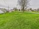 Expansive backyard with lush green grass and mature trees, offering plenty of space at 301 E 34Th St, Anderson, IN 46013