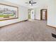 Bright living room featuring neutral carpet, a large picture window, and an open entryway at 301 E 34Th St, Anderson, IN 46013