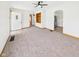 Spacious living room featuring neutral carpet, an open entryway, and a glimpse into the modern kitchen at 301 E 34Th St, Anderson, IN 46013