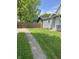 The grassy backyard shows the home's exterior, a sidewalk, and a fence at 3031 Nowland Ave, Indianapolis, IN 46201