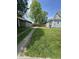 The grassy backyard shows the home's exterior, a sidewalk, and a fence at 3031 Nowland Ave, Indianapolis, IN 46201