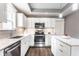 Well-lit kitchen features stainless steel appliances, granite countertops, dark hardwood floors, and bright white cabinetry at 3031 Nowland Ave, Indianapolis, IN 46201