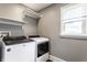 Laundry room with a Whirlpool washer and dryer, a window providing natural light, and shelving at 3031 Nowland Ave, Indianapolis, IN 46201