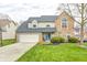 Charming two-story home with brick and vinyl siding, well-manicured lawn, and attached two-car garage at 3051 Firestone Cir, Indianapolis, IN 46234