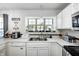 Bright kitchen features white cabinets and countertops, complete with stainless steel appliances at 3051 Firestone Cir, Indianapolis, IN 46234