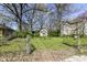 Exterior view of the house features a small structure with a window and lush green lawn, surrounded by trees and a blue sky at 324 E Burgess Ave, Indianapolis, IN 46219