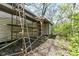 Exterior of an aged shed showing weathered siding and scaffolding, set amongst overgrown plants and trees at 324 E Burgess Ave, Indianapolis, IN 46219