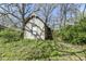 Exterior view of a unique shed with scaffolding around the structure with an overgrown lot at 324 E Burgess Ave, Indianapolis, IN 46219
