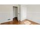 Hallway featuring a paneled wall and wood flooring, leading to additional rooms and closets at 3255 W 30Th St, Indianapolis, IN 46222