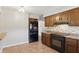 Efficient kitchen featuring black appliances, wood cabinets and a tile backsplash at 3255 W 30Th St, Indianapolis, IN 46222