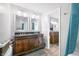 A bathroom with a dark wood vanity, double mirrors, and wood-look tile at 3331 Daniel St, Mooresville, IN 46158