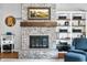 Living room with a brick fireplace, wooden mantle and custom shelving enhancing the cozy and inviting space at 3331 Daniel St, Mooresville, IN 46158