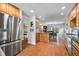 Kitchen with wooden cabinets, stainless steel fridge, hardwood flooring and view to dining and living area at 3331 Daniel St, Mooresville, IN 46158
