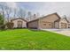 Charming single-story home featuring a brick facade, attached garage and well-maintained lawn at 3629 Woodglen Way, Anderson, IN 46011