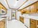 Traditional kitchen featuring wood cabinets, white appliances, and an open doorway to the backyard at 3629 Woodglen Way, Anderson, IN 46011