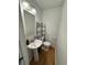 Compact bathroom featuring a pedestal sink, toilet, and storage at 3703 E Gore St, Columbus, IN 47201