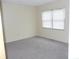 Bright bedroom with neutral carpet and a large window for ample natural light at 3744 Tudor Park Dr # 2, Indianapolis, IN 46235