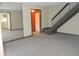 Open living room featuring neutral carpet, a stairway, and a mirrored wall at 3744 Tudor Park Dr # 2, Indianapolis, IN 46235