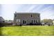 Two-story house with a large backyard featuring green grass, a patio, and mature trees at 3896 Woods Bay Ln, Plainfield, IN 46168