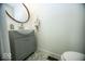 Powder room featuring a modern vanity, decorative mirror, and stylish tile flooring at 3896 Woods Bay Ln, Plainfield, IN 46168