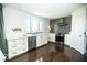 Bright kitchen with white cabinets, stainless steel appliances, a large window, and hardwood floors at 3896 Woods Bay Ln, Plainfield, IN 46168