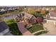 Aerial view of brick home with circular drive, lush lawn and mature trees at 4052 Diamond Row, Greenwood, IN 46143