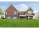 Brick home showcasing backyard with balconies and expansive lawn at 4052 Diamond Row, Greenwood, IN 46143