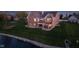 Picturesque brick home with a spacious wooden deck overlooking a lush green lawn and a serene lake at 4052 Diamond Row, Greenwood, IN 46143