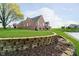 Well-maintained brick home featuring a lush green lawn and a charming stone retaining wall at 4052 Diamond Row, Greenwood, IN 46143