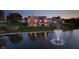 Stunning brick home with a walkout deck overlooking a tranquil lake and fountain at twilight at 4052 Diamond Row, Greenwood, IN 46143