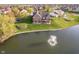 Beautiful brick home featuring a well-maintained lawn, mature trees, and a serene pond with a fountain at 4052 Diamond Row, Greenwood, IN 46143