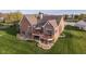 A beautiful brick home features a large deck and patio, surrounded by a lush green lawn at 4052 Diamond Row, Greenwood, IN 46143