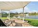 Relaxing covered patio with comfortable lounge chairs offering serene views of the pond with fountain at 4052 Diamond Row, Greenwood, IN 46143