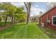 Expansive backyard with lush lawn and mature trees, adjacent to the house's red exterior at 426 Oakwood Dr, Indianapolis, IN 46260