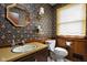 Well-decorated bathroom with sink, toilet, wood paneling, and floral wallpaper at 426 Oakwood Dr, Indianapolis, IN 46260