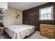 Well-lit bedroom with a full bed, cork accent wall, a window, and a three-drawer chest for storage at 426 Oakwood Dr, Indianapolis, IN 46260