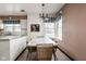 Cozy dining area features vintage chandelier, wallpaper, and adjacent access to the kitchen with natural light from windows at 426 Oakwood Dr, Indianapolis, IN 46260