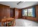 Dining room featuring wood paneling, a basic table and chairs, and a window with curtains at 426 Oakwood Dr, Indianapolis, IN 46260