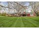 Full home exterior showcasing lush lawn, mature trees, brick and red siding at 426 Oakwood Dr, Indianapolis, IN 46260