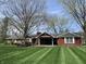 Charming ranch-style home featuring a brick exterior, covered porch and meticulously striped front lawn at 426 Oakwood Dr, Indianapolis, IN 46260