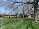 Beautifully landscaped property with mature trees surrounding a classic ranch-style brick home at 426 Oakwood Dr, Indianapolis, IN 46260