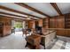 Spacious living room with wooden beams, wood paneling, built-in shelving, and sliding glass doors at 426 Oakwood Dr, Indianapolis, IN 46260