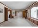 Spacious living room featuring a large window seat, neutral carpet, and multiple doorways at 426 Oakwood Dr, Indianapolis, IN 46260
