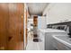 Utility room features washer, dryer, sink, wood cabinets, and tile flooring that opens up to another room at 426 Oakwood Dr, Indianapolis, IN 46260