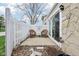 A cozy backyard patio with two chairs, white fence, and stone siding. Perfect for relaxing outdoors at 43 Dominion Dr, Zionsville, IN 46077